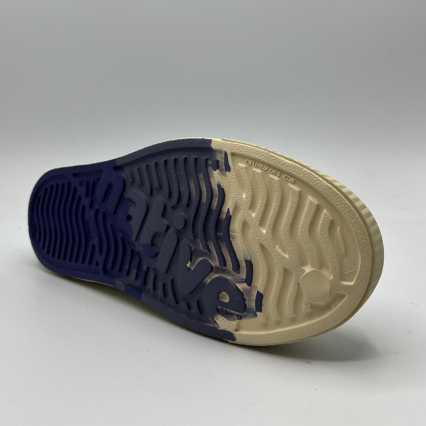 Bottom facing view of an algae foam slip on shoe and with a perforated upper and ultra lightweight design.