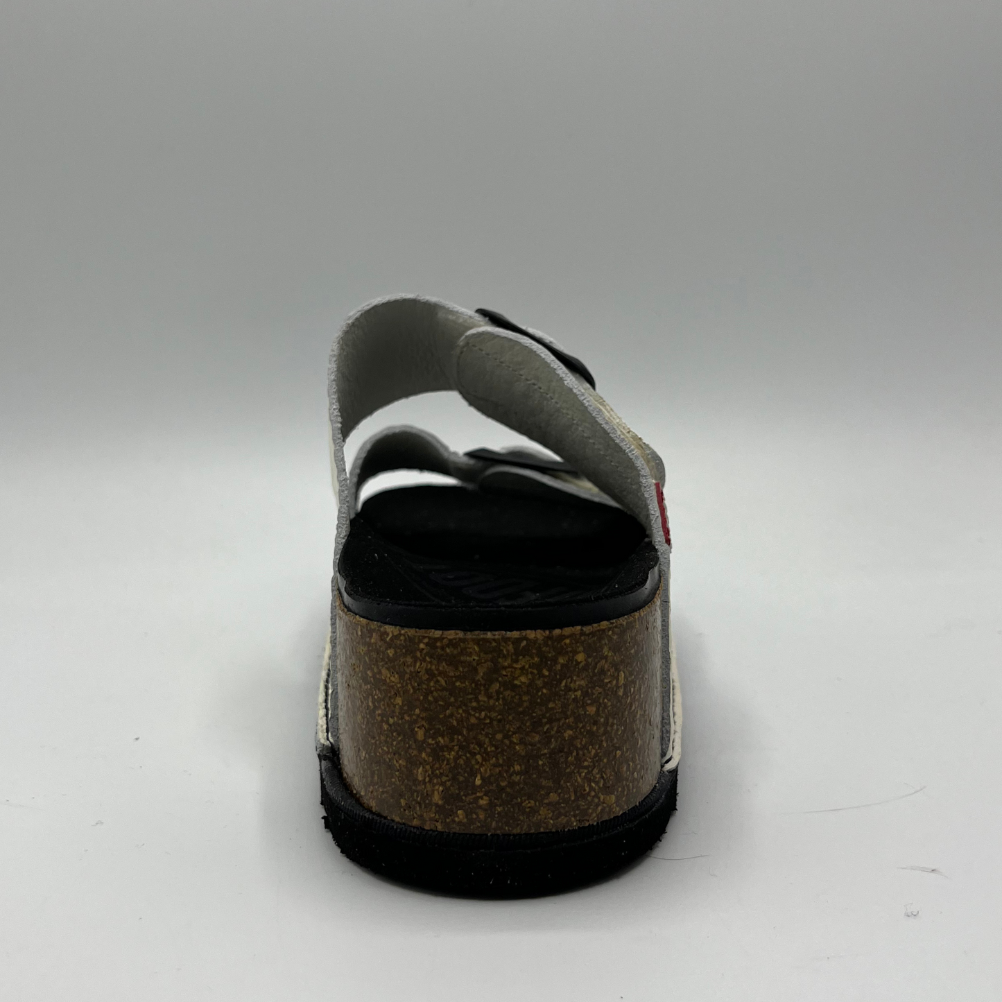 Back view of a platform sandal in a pebbled white leather. Two thick straps across with adjustable buckles.