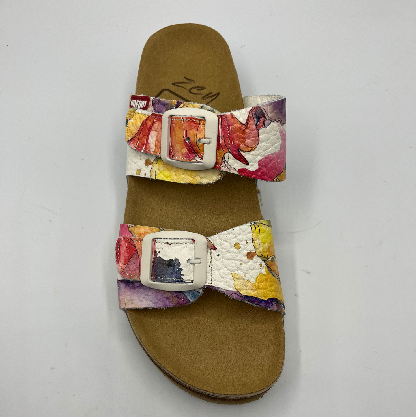 Top view of a leather strapped sandal with a floral watercolour pattern, two adjustable straps and a contoured footbed.
