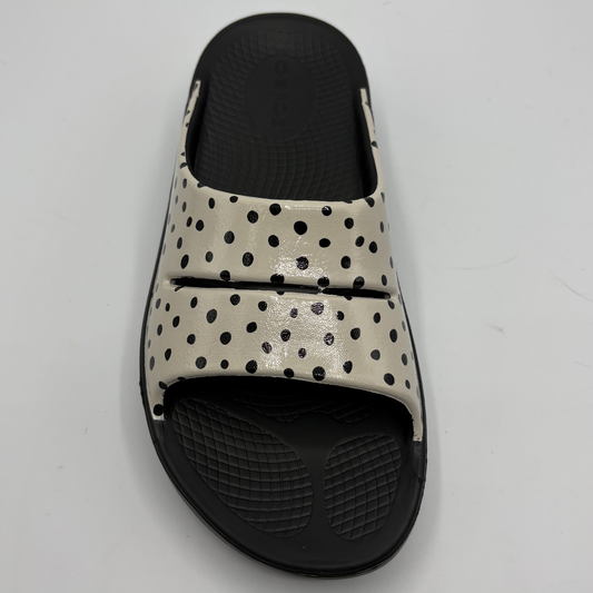 Black and beige polka dot slide sandal on a light gray background
