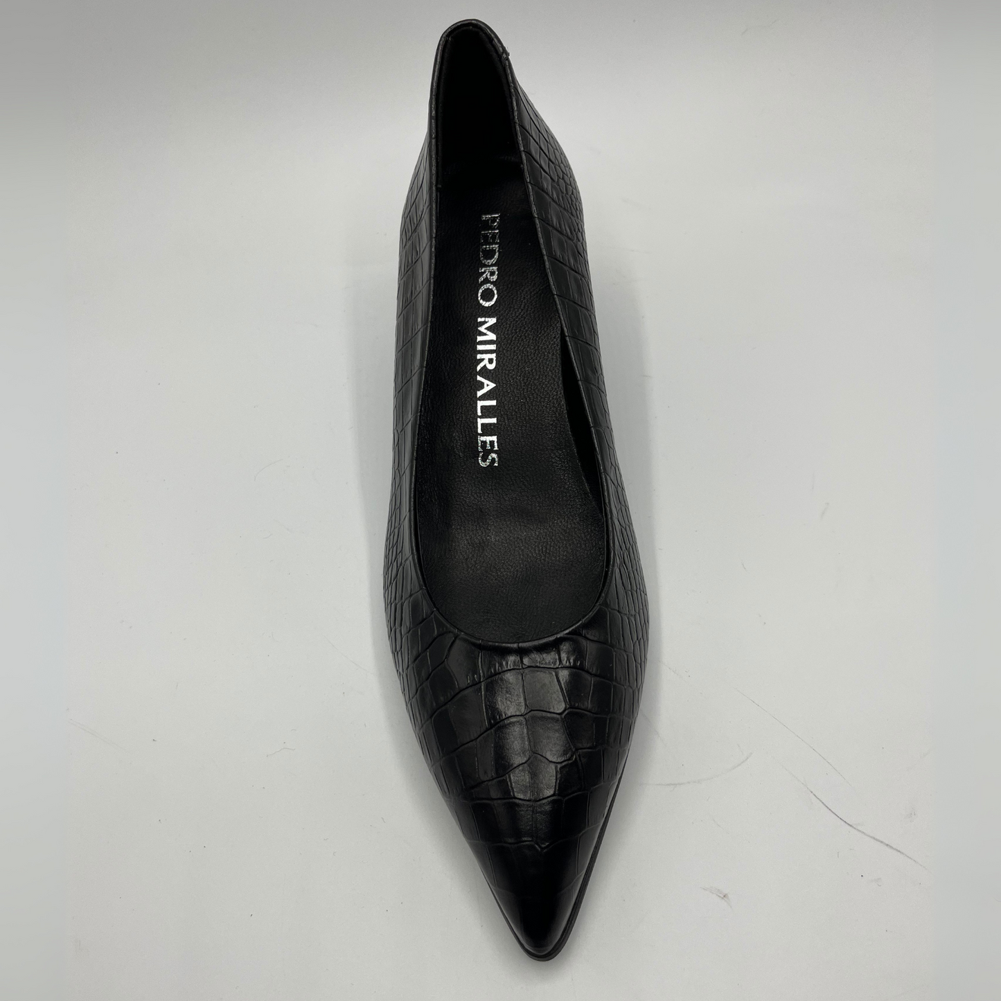 Black pointed-toe shoe with 'Pedro Miralles' branding on a light gray background