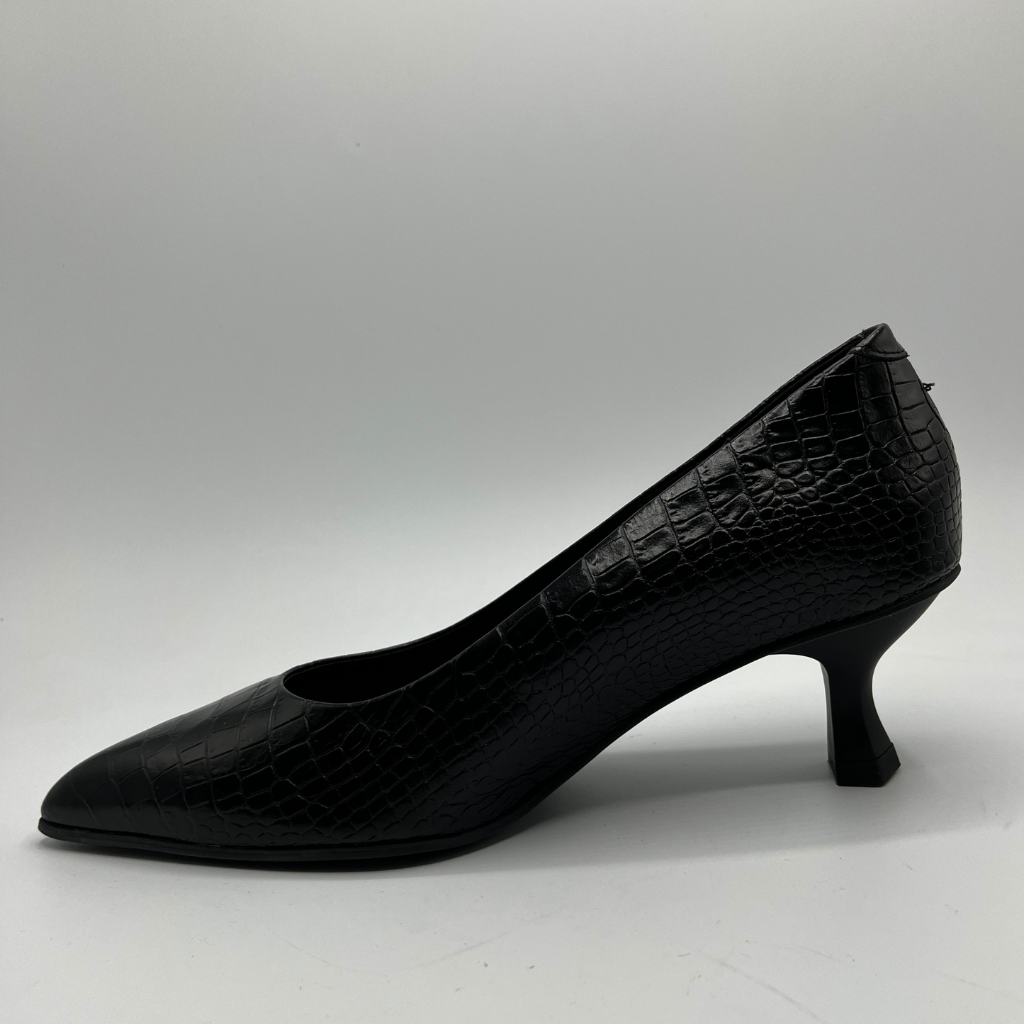 Black high-heeled shoe with a textured surface on a white background