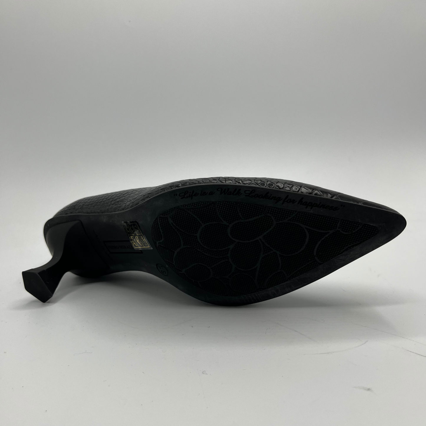 Black shoe sole with embossed pattern on a white background