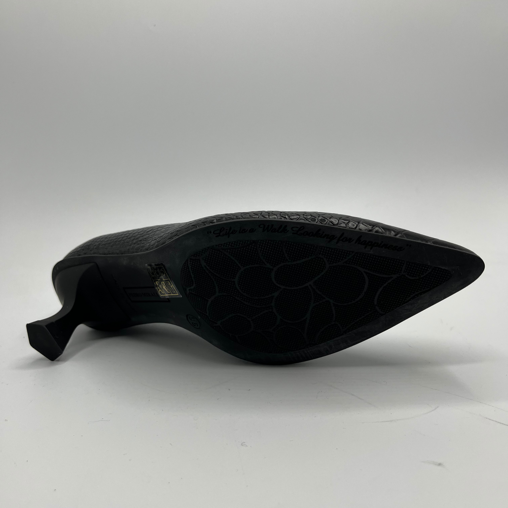 Black shoe sole with embossed pattern on a white background