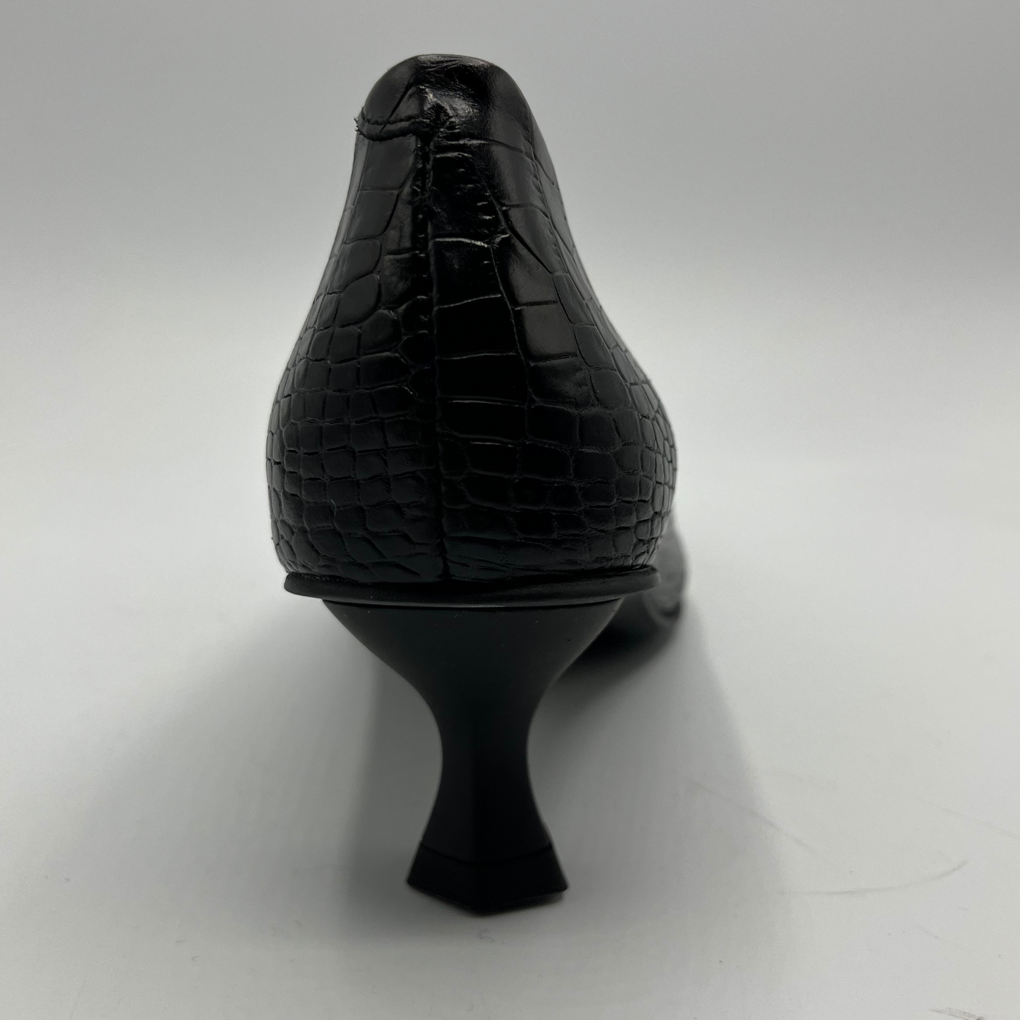 Black high-heeled shoe with textured heel on a white background