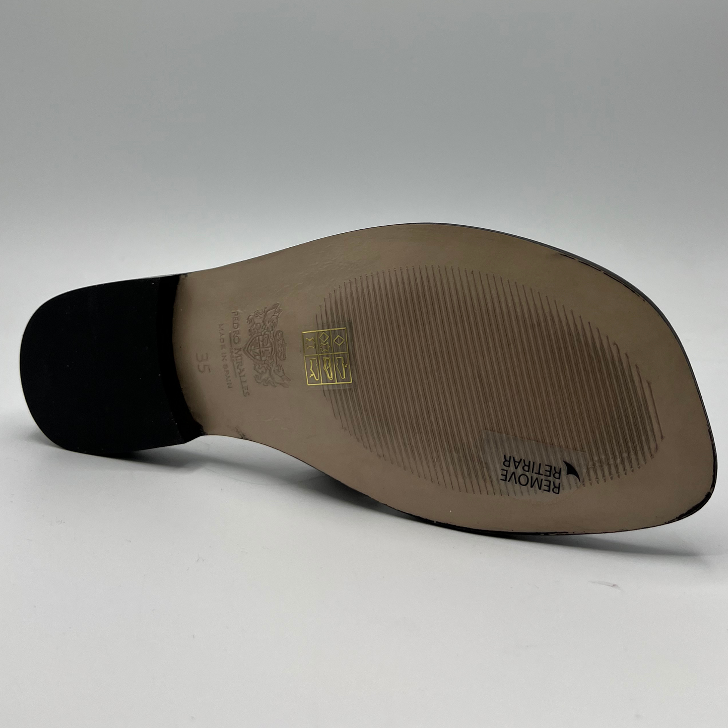 Bottom view of a snake print leather flat sandal with a leather lining and upper.