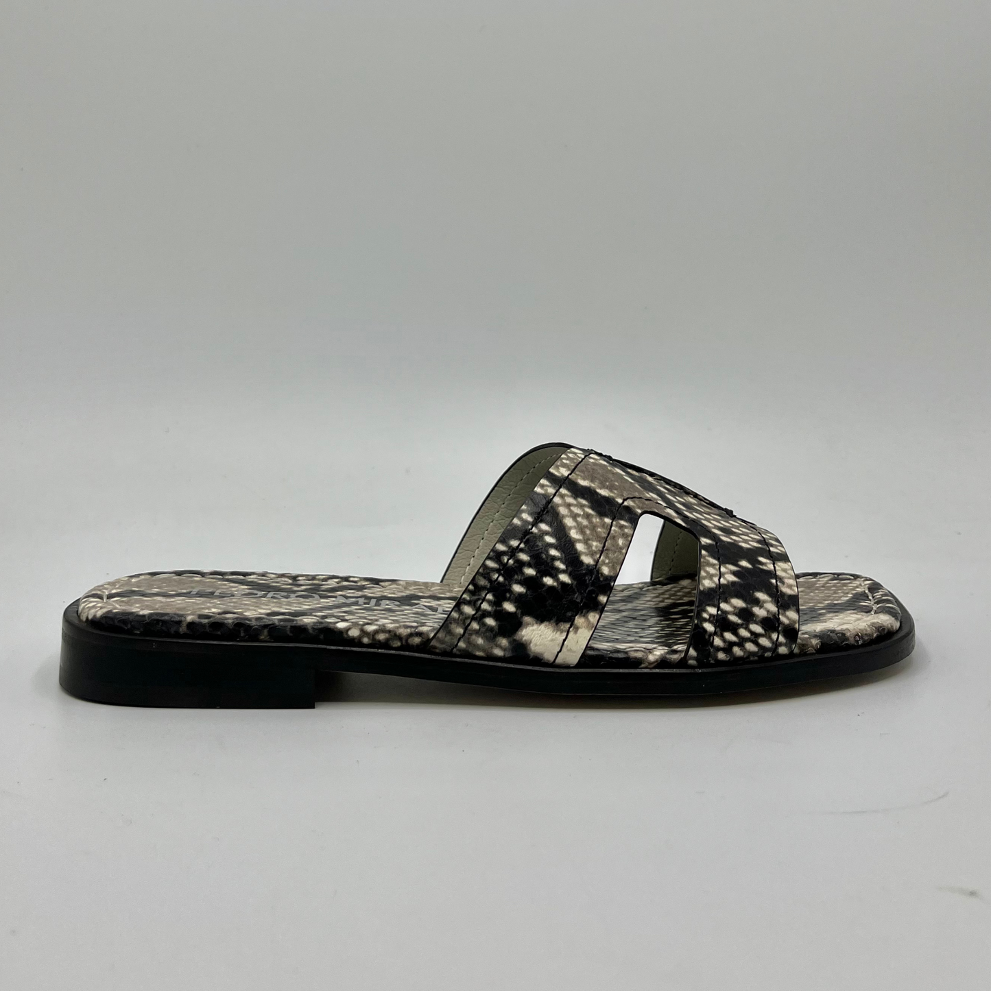 Right facing view of a snake print leather flat sandal with a leather lining and upper.
