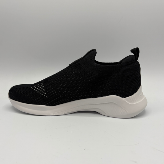 Black slip-on sneaker with white sole on a gray background