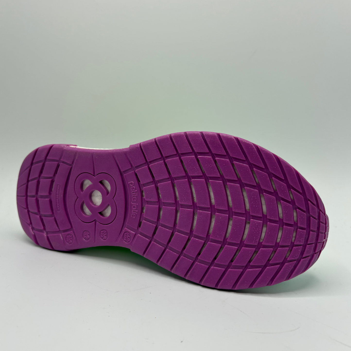 Purple shoe sole with textured pattern on a gray background