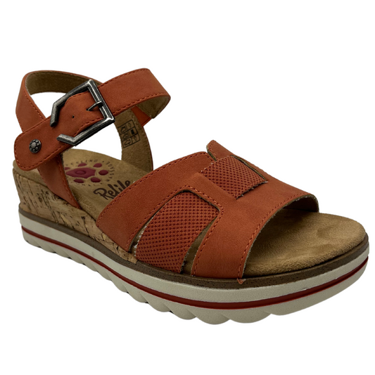 45 degree angled view of wedge sandal with rusty orange textile upper straps. Metal buckle on ankle strap