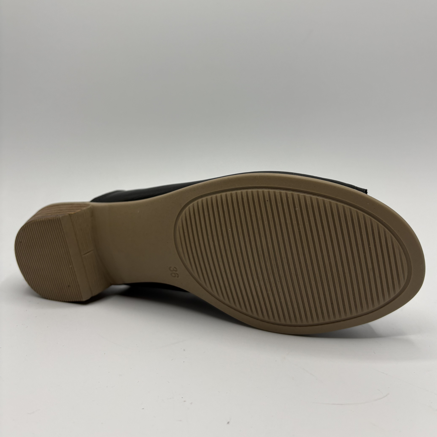 Black shoe sole with brown tread pattern on a white background