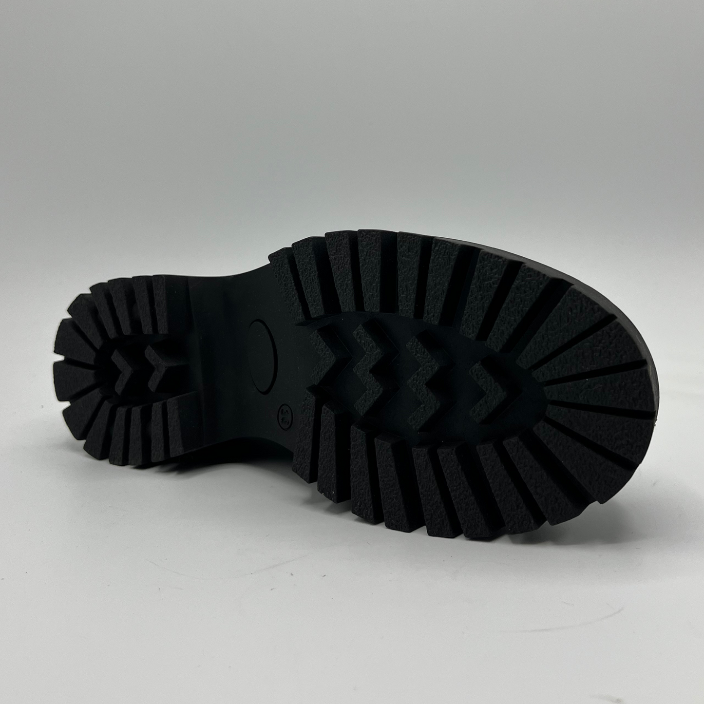 Close-up of a black rubber sole on a white background