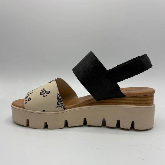 Beige sandal with black strap on a gray background