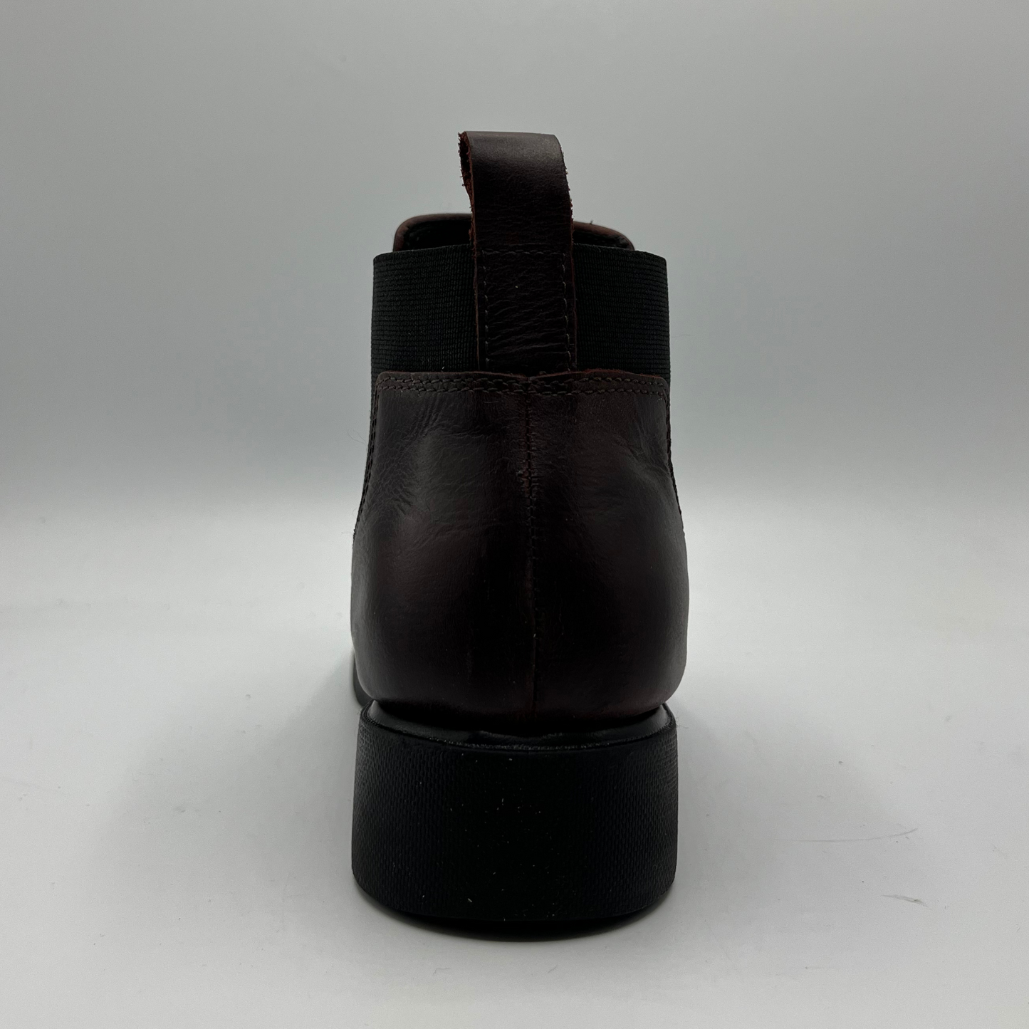 Black leather boot on a gray background