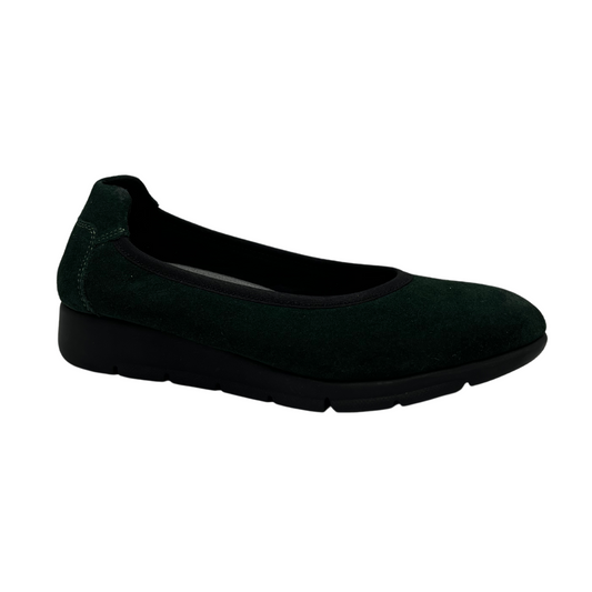 45 degree angled view of green suede low wedge shoe with black outsole and rounded toe