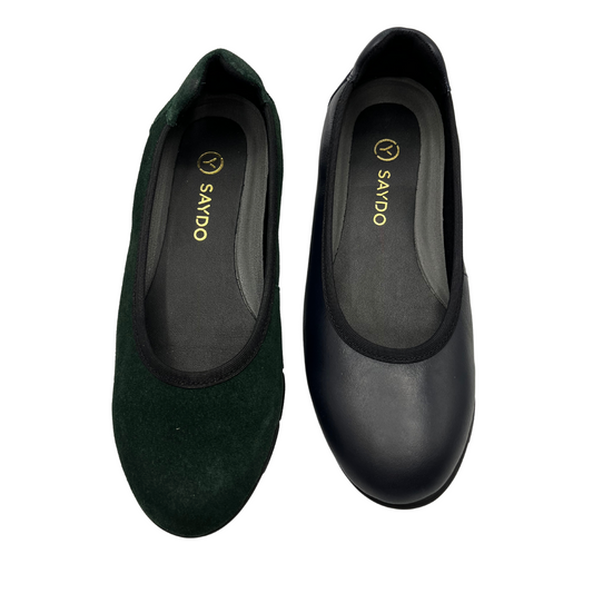 Top view of low wedge shoes beside each other. One is green with a suede finish and the other is navy. Both have a rounded toe and textile lining