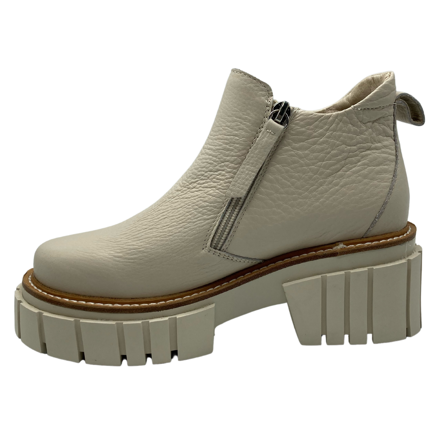 Left facing view of bone coloured leather ankle boot with chunky rubber outsole and side zipper entry