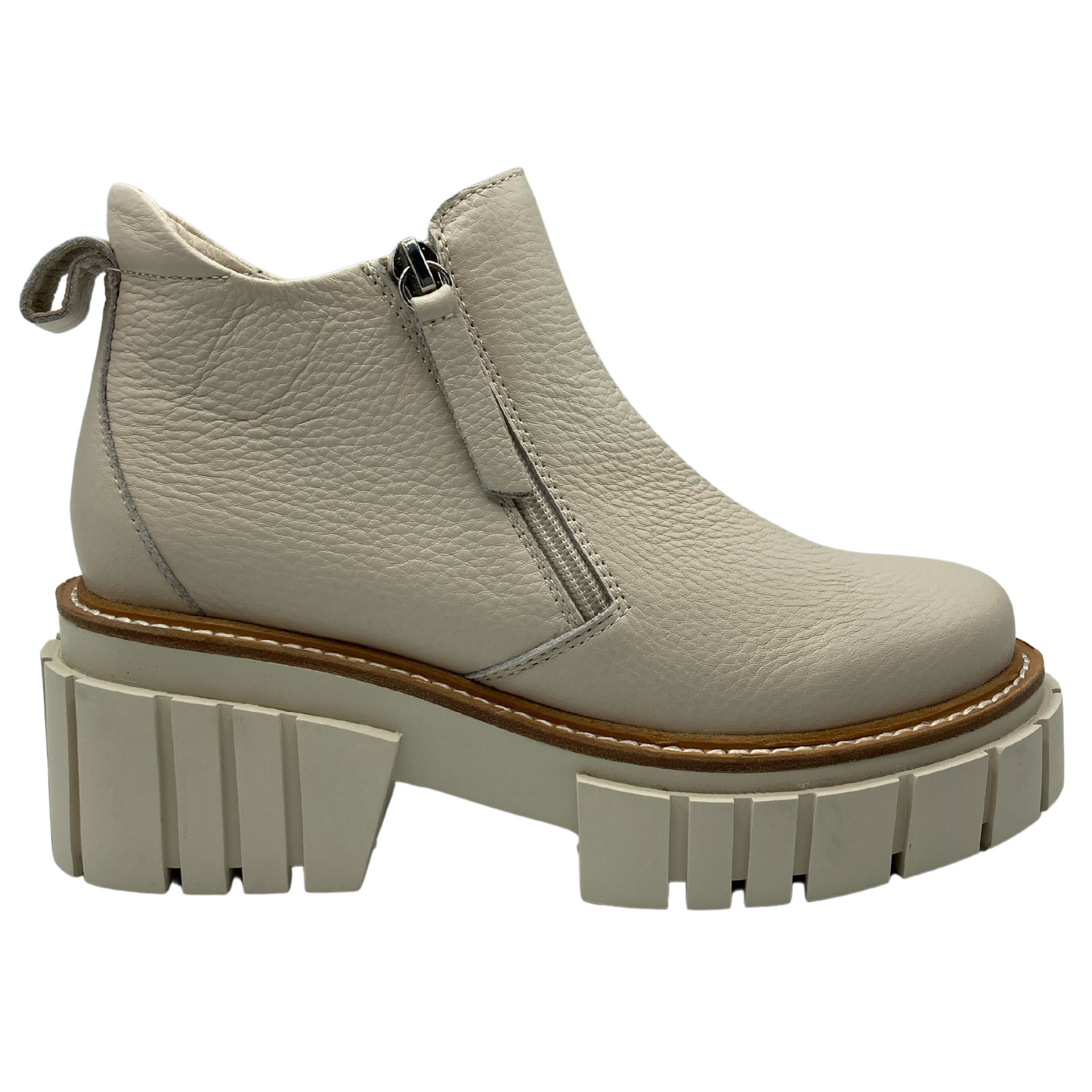 Right facing view of bone leather ankle boot with zipper entry, rear pull tab and chunky rubber outsole