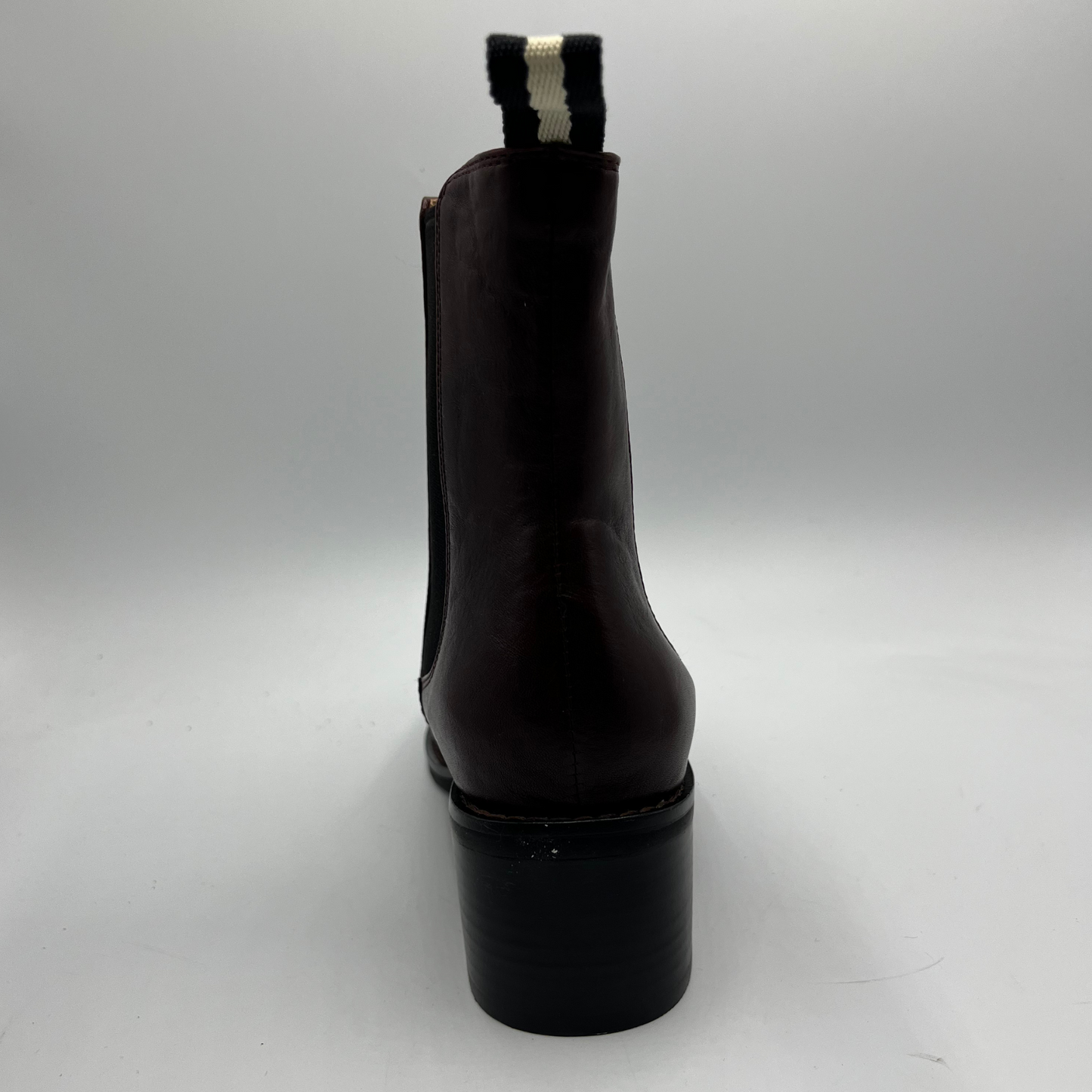 Black ankle boot with a chunky heel on a light gray background