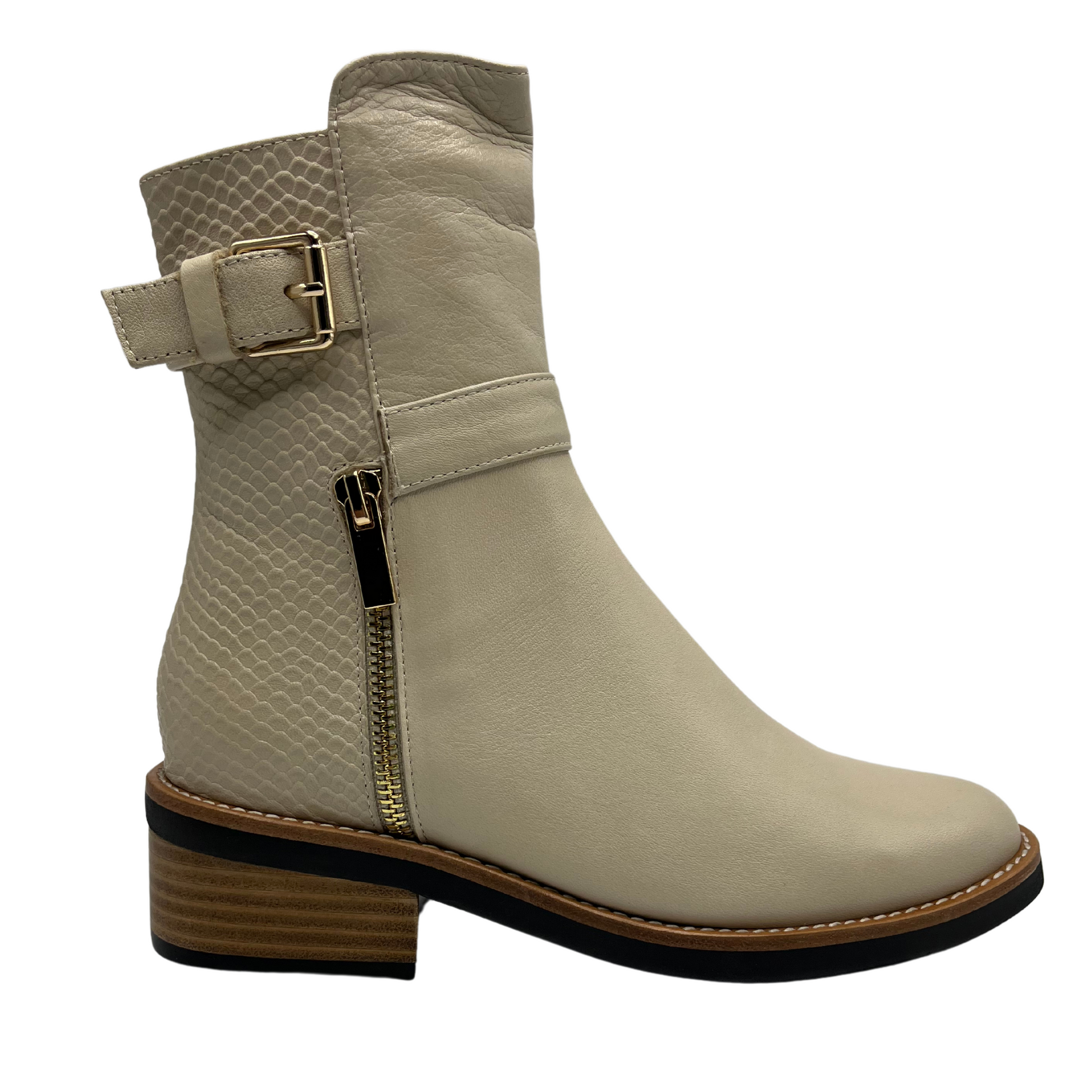 Right facing view of nude short boot with metallic gold accents. Adjustable ankle strap and short block heel.