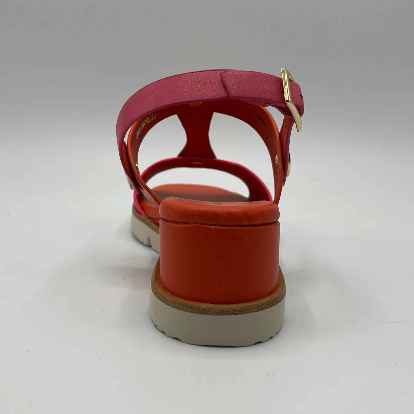 Back view of a fuschia and orange leather sandal with a wedge heel, adjustable ankle strap and shiny gold details.