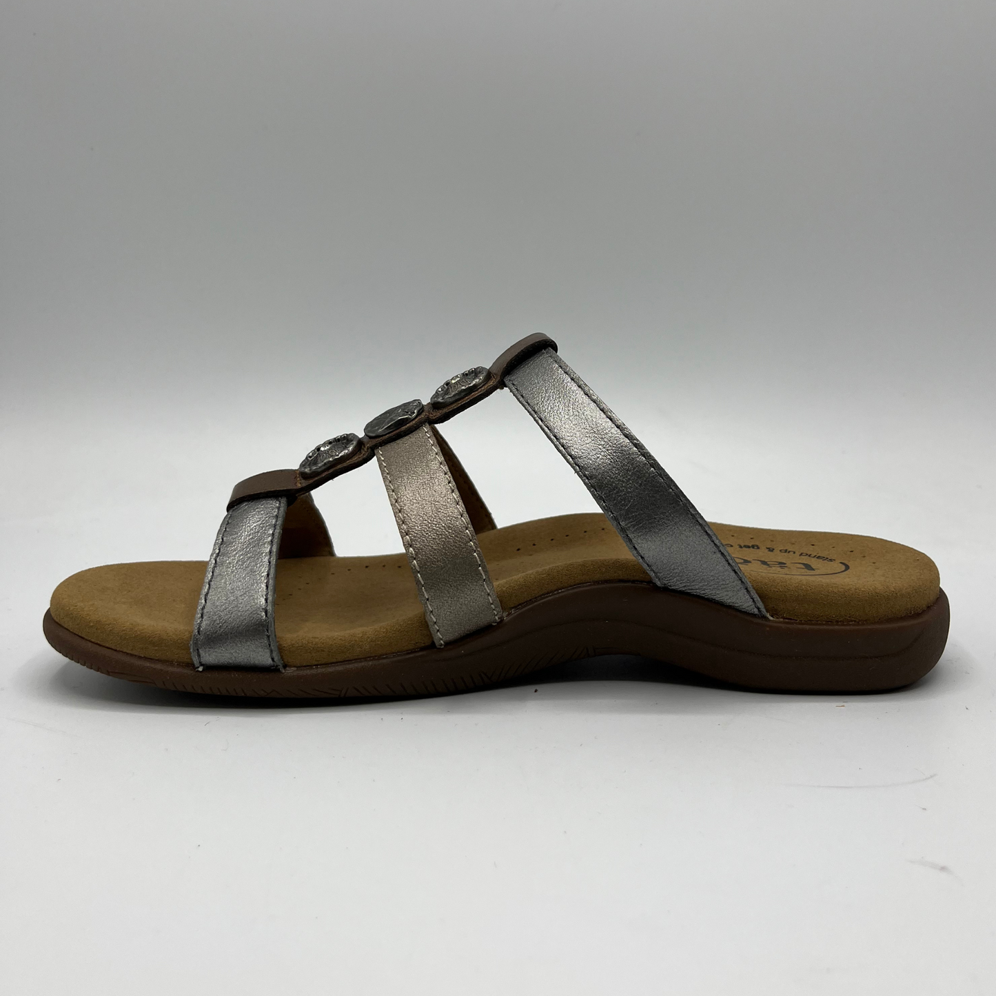 Left facing view of leather sandal with 3 straps and slip on style. Hook and loop closures on straps and lined anatomical footbed