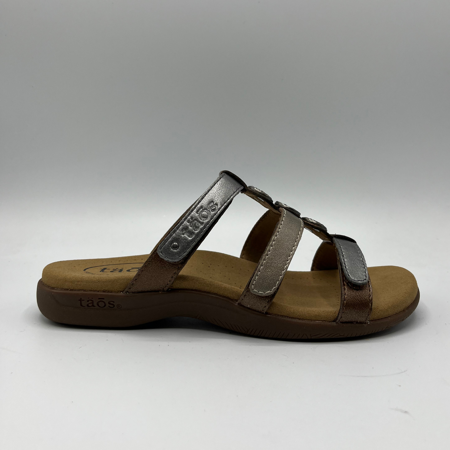 Right facing view of leather sandal with 3 straps and slip on style. Hook and loop closures on straps and lined anatomical footbed