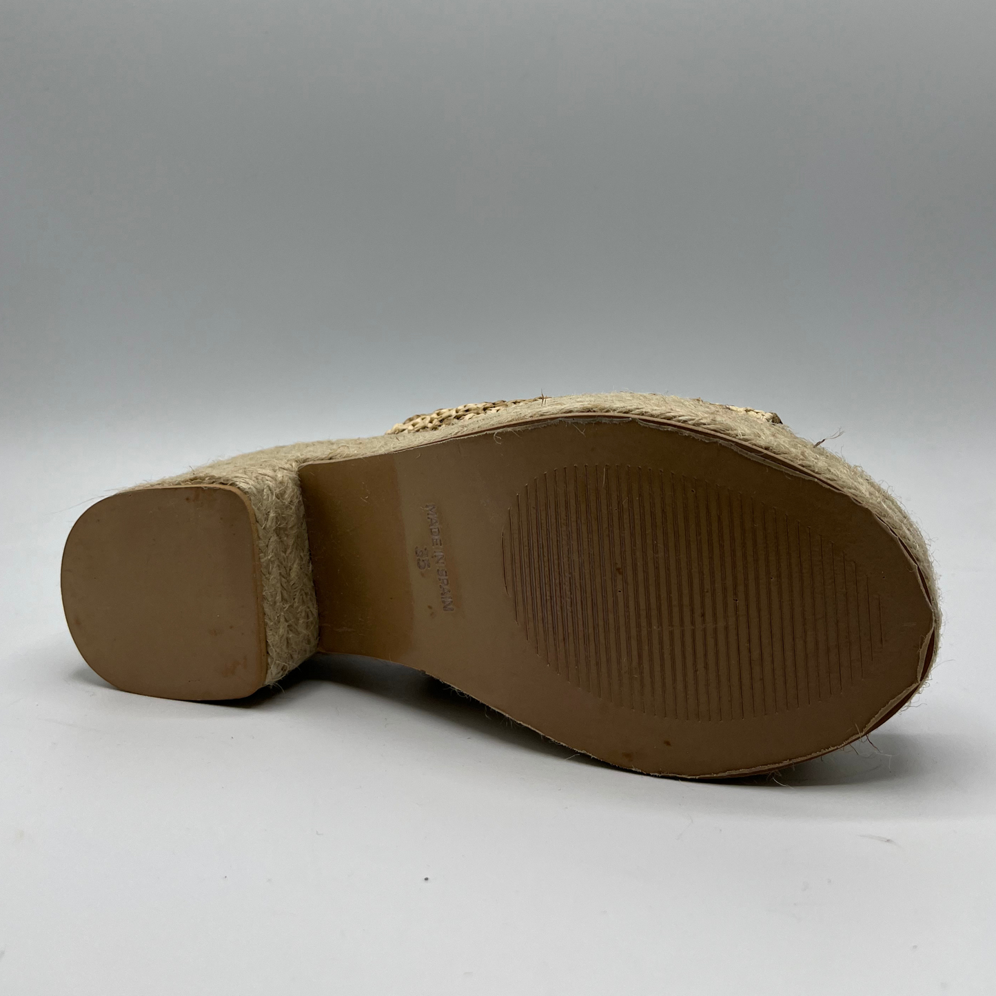Bottom view of a chunky wedge heel with an elasticated slingback strap and peep toe.