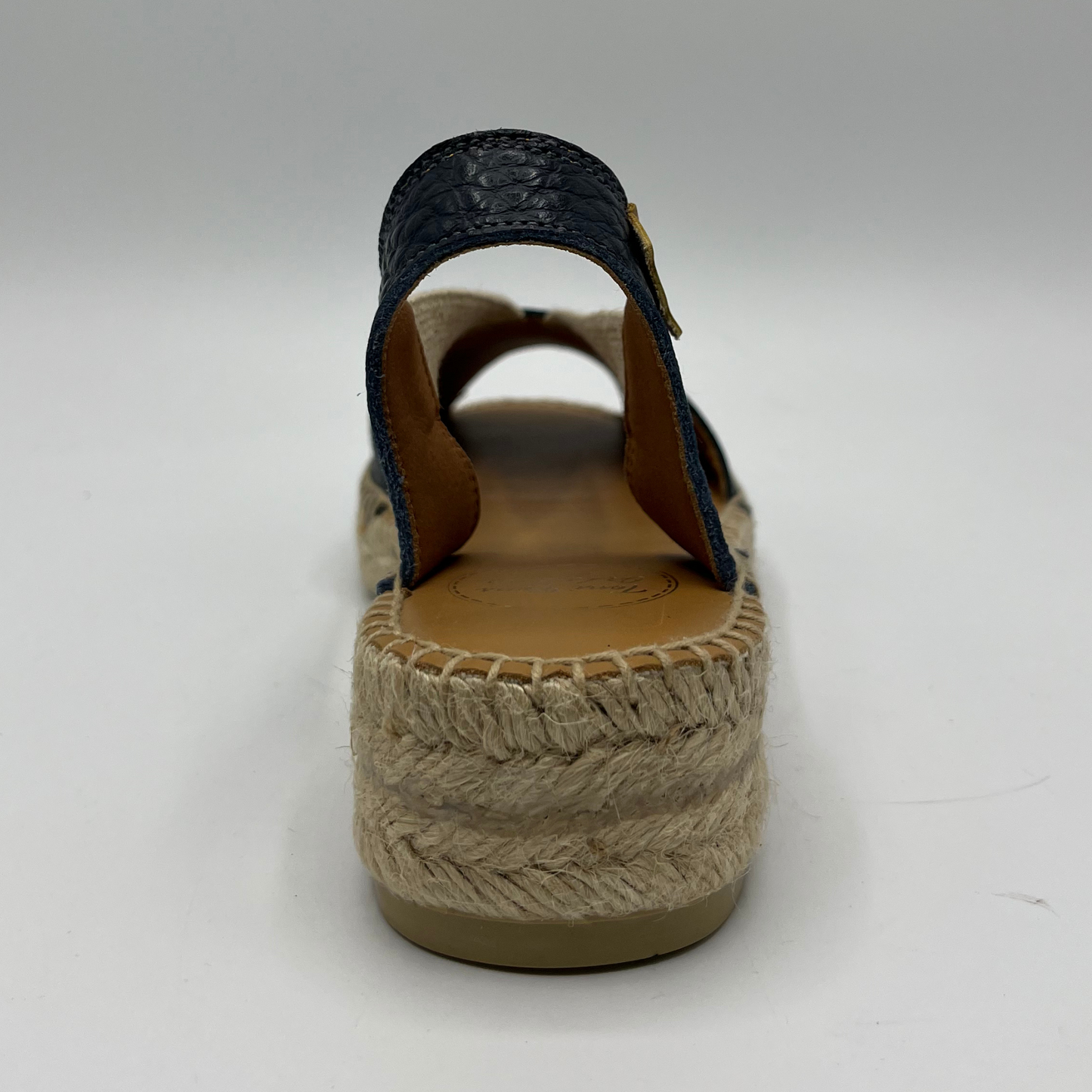 Back view of an espadrille soled sandal with elasticated side straps and platinum leather straps.