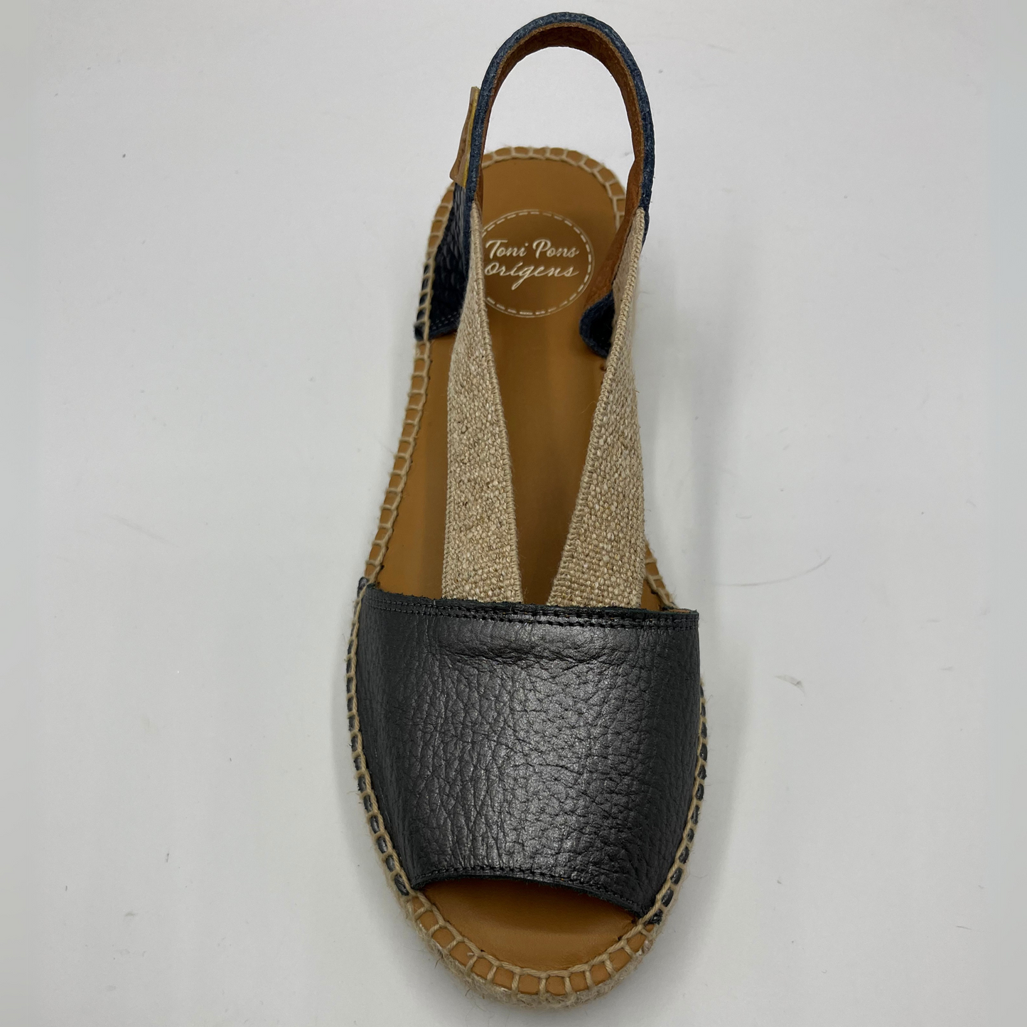 Top view of an espadrille soled sandal with elasticated side straps and platinum leather straps.