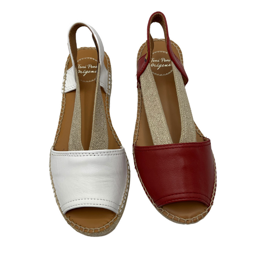 Top view of two leather sandals side by side. White on the left and red on the right. Both with elasticated straps and peep toes