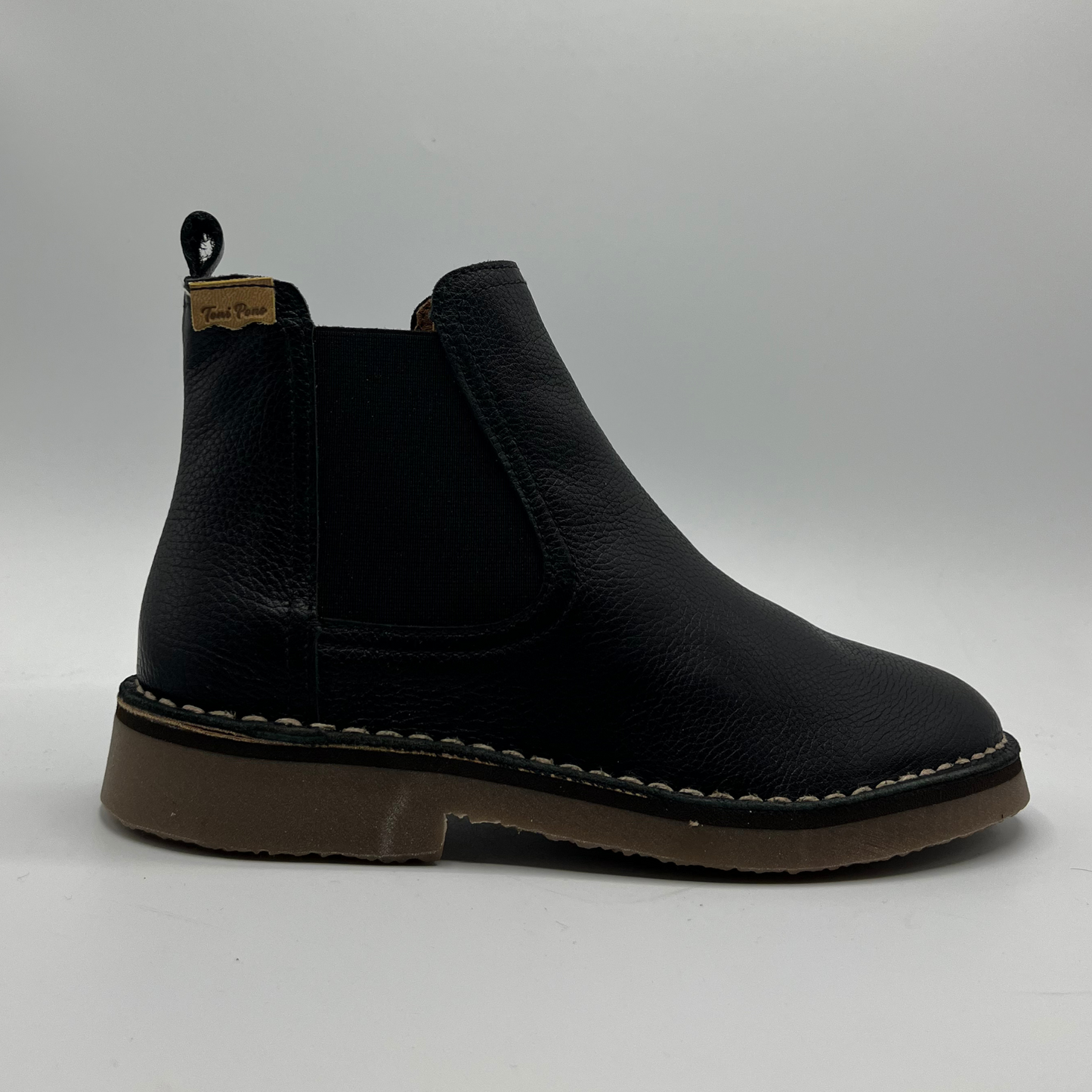 Black leather boot on a light gray background