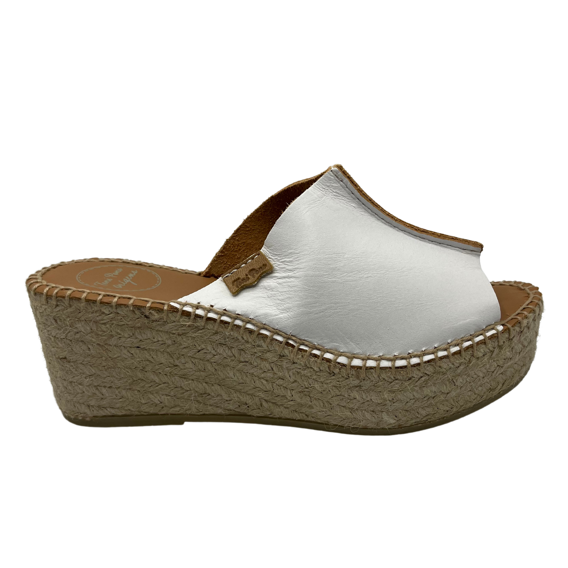Right facing view of a white leather espadrille sandal with wedge heel and stitching round sole