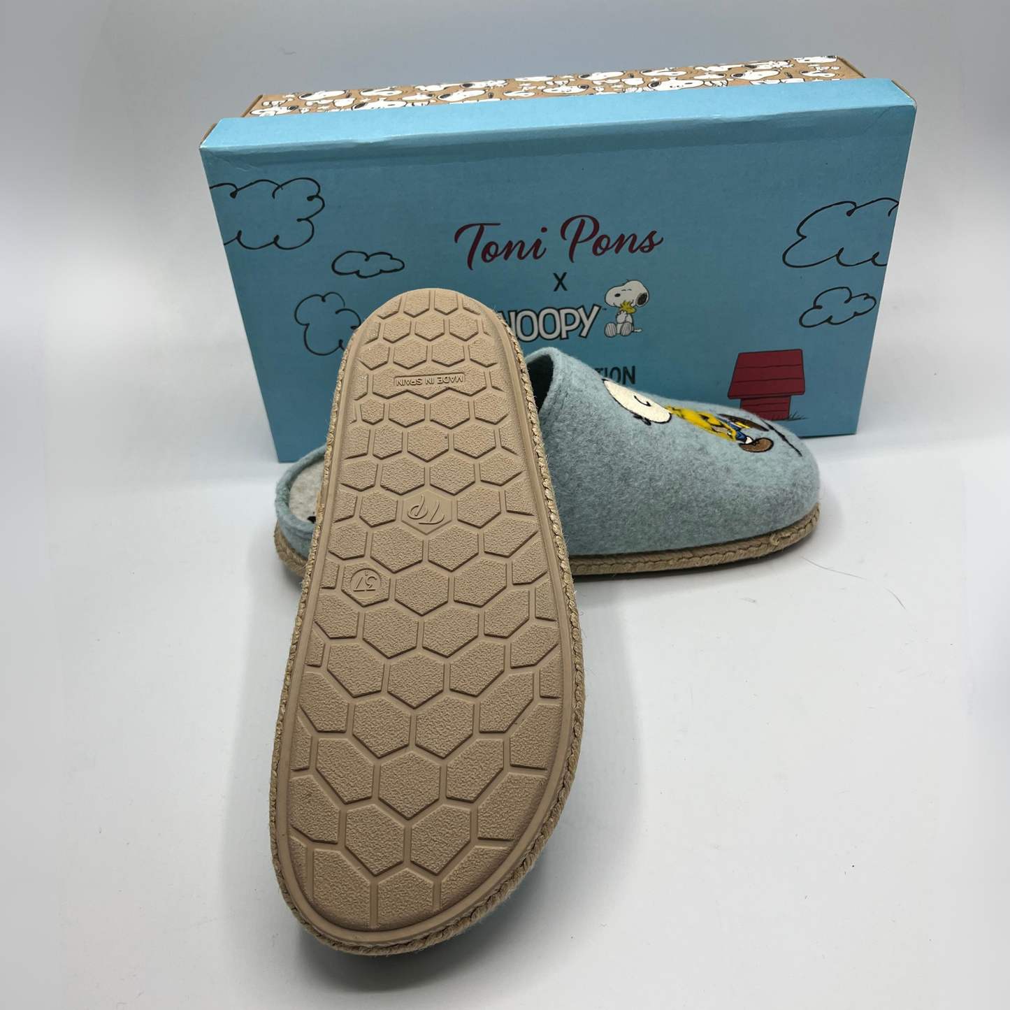 Blue slippers with a textured sole and Snoopy design, displayed in front of a blue box with 'Toni Pons' branding.