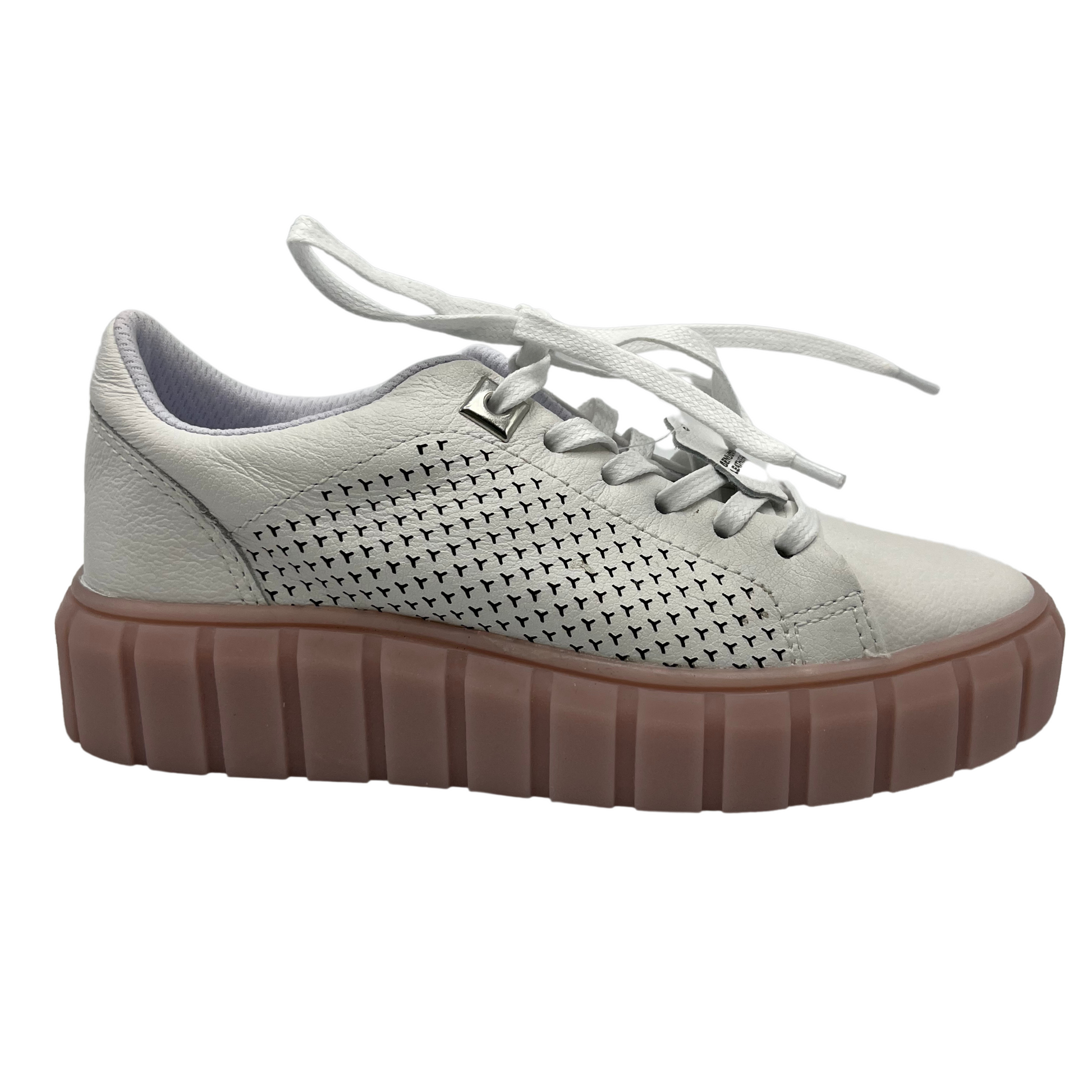 Right facing view of white leather sneakers with rose coloured platform rubber outsole. White laces and perforated leather details on the sides.