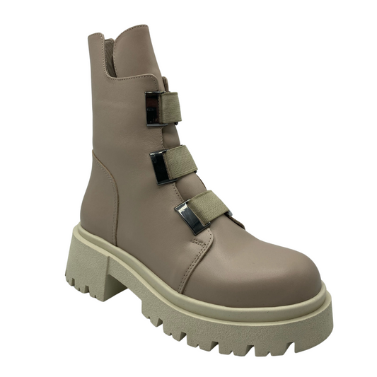 45 degree angled view of nude leather boot with 3 buckle straps and chunky rubber sole