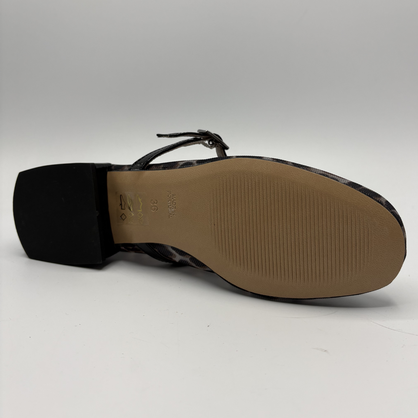 Black sandal with a tan sole on a white background