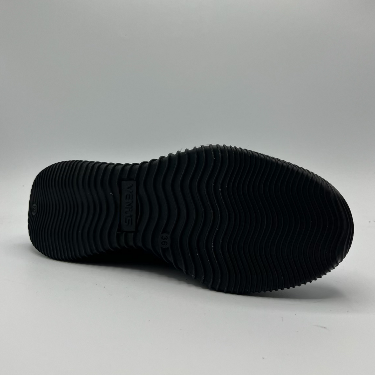 Black sole of a shoe on a gray background