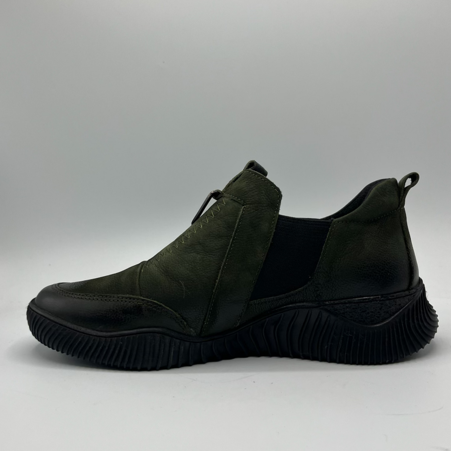 Dark green slip-on shoe on a gray background