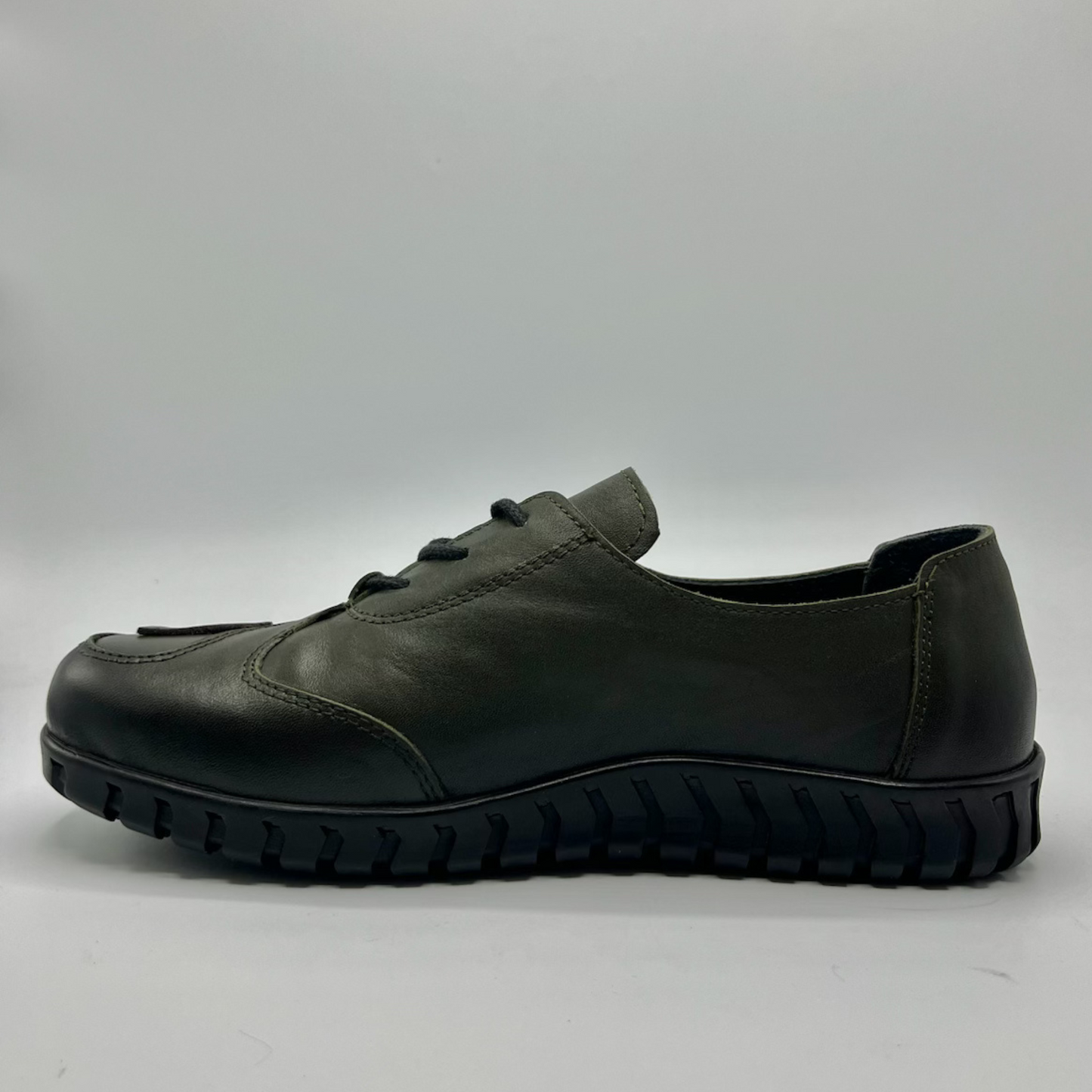 Green leather shoe on a gray background