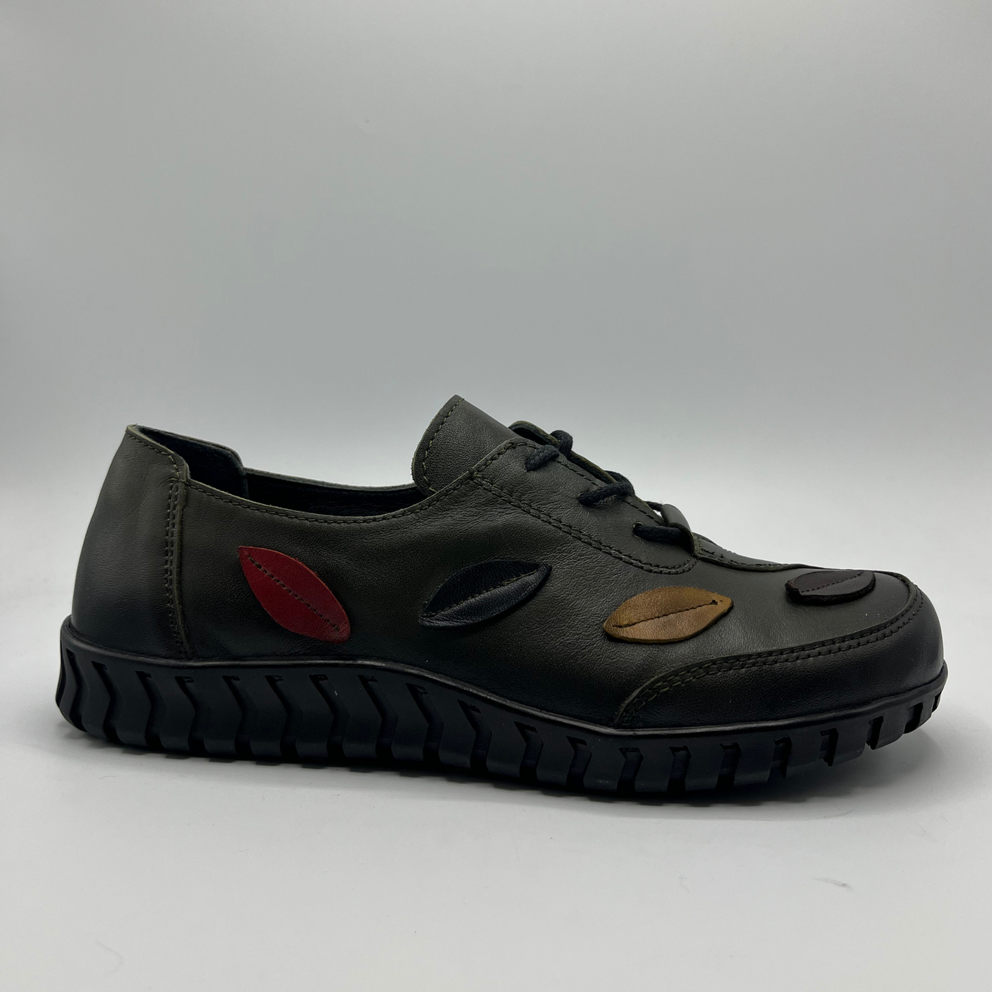Olive shoe with unique design elements on a gray background