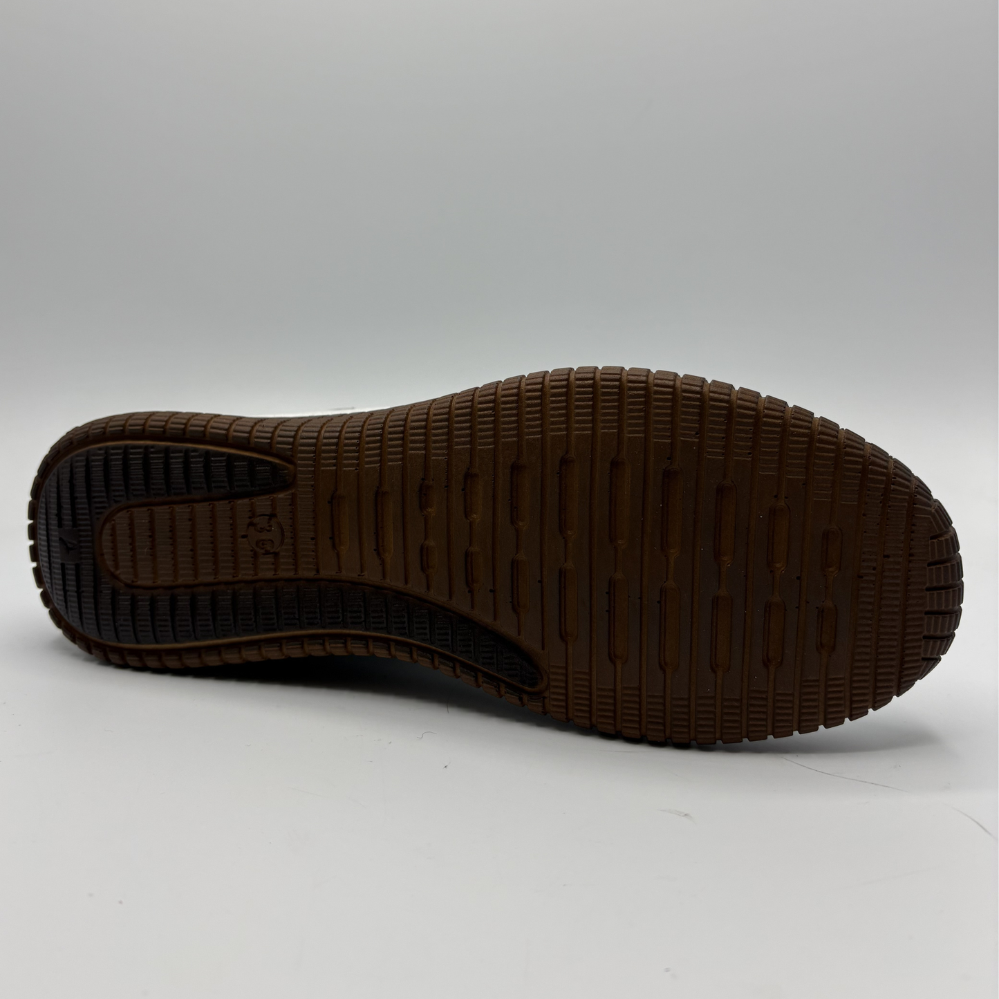 Brown sole of a shoe on a light gray background