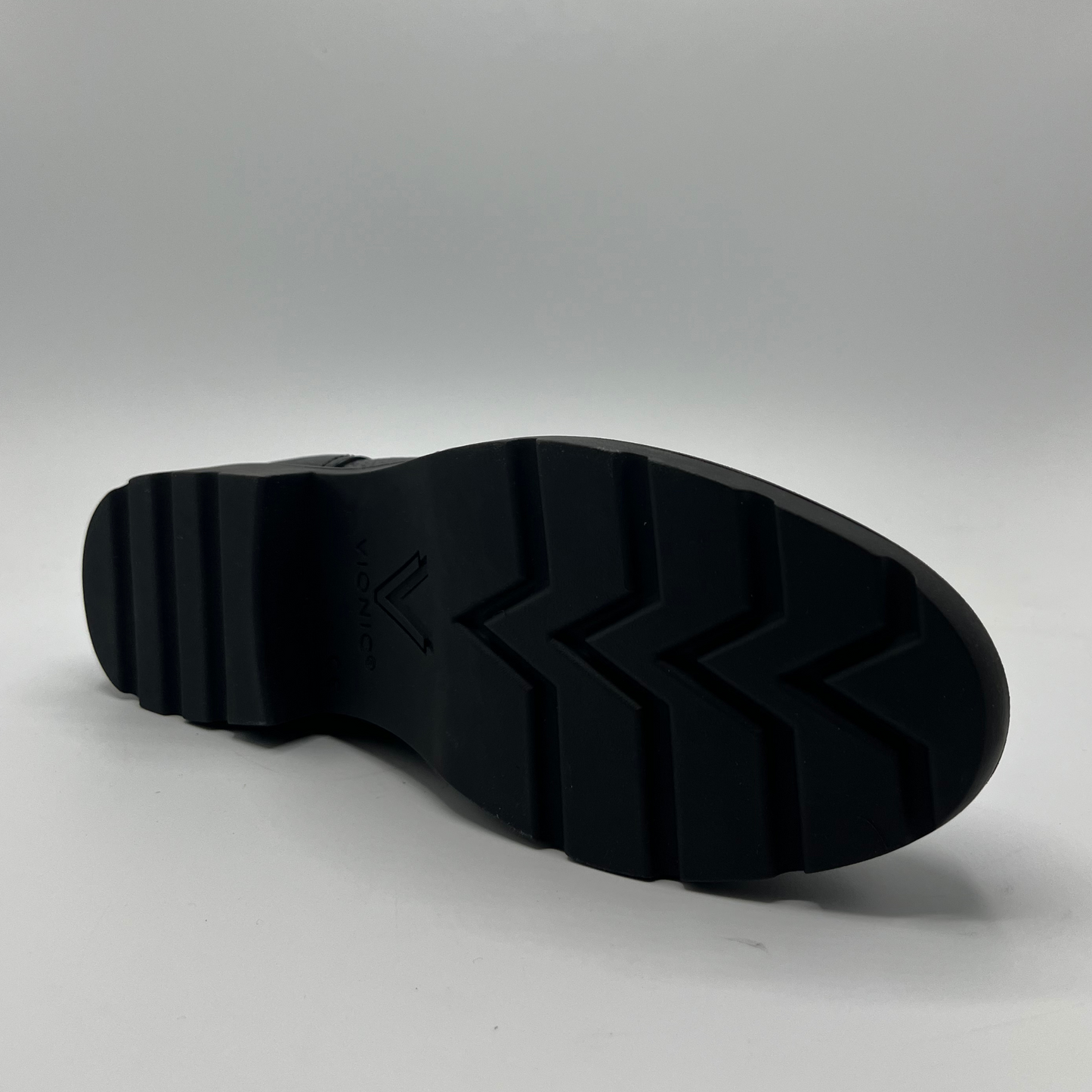 Bottom view of a black leather ankle boot.