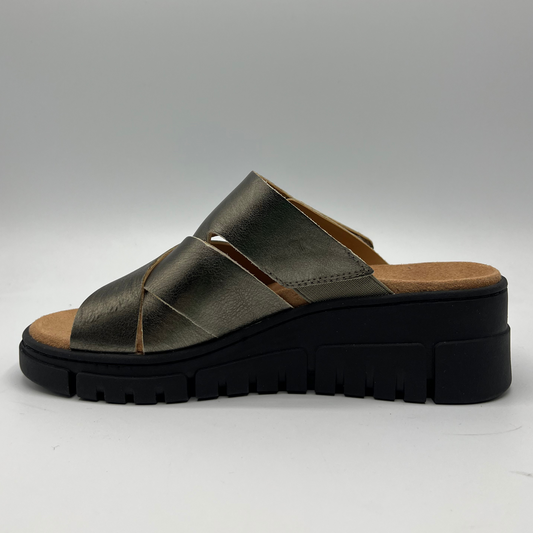Left facing facing view of a leather strapped sandal with an adjustable hook and loop strap and a black wedge heel.