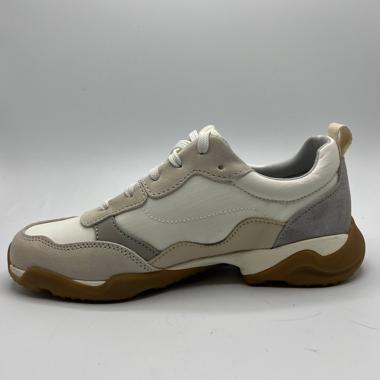 White and gray sneaker with brown sole on a white background