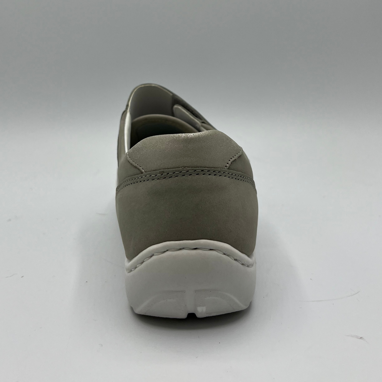 Back view of a grey sneaker with a velcro strap and a contoured footbed.