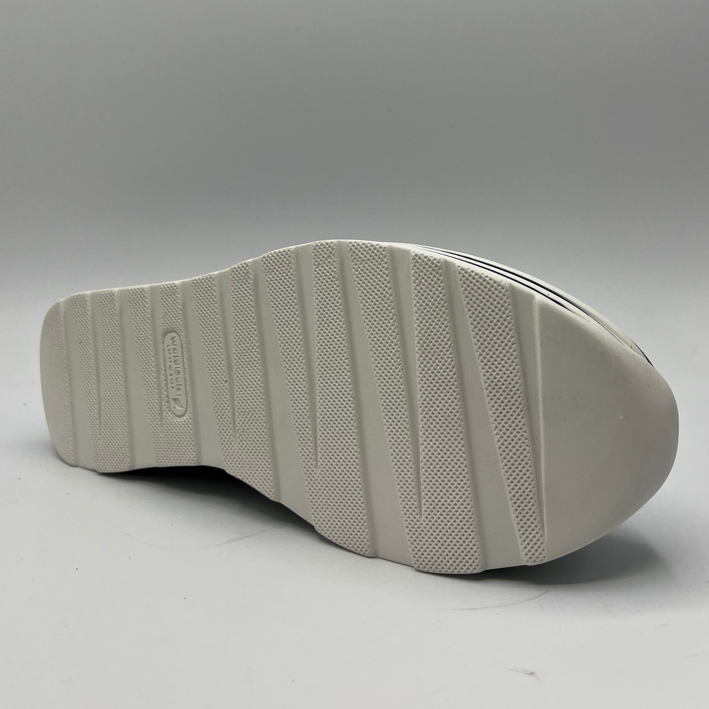 Bottom view of a navy leather sneaker with a white rubber outsole with laces and a side zipper closure.