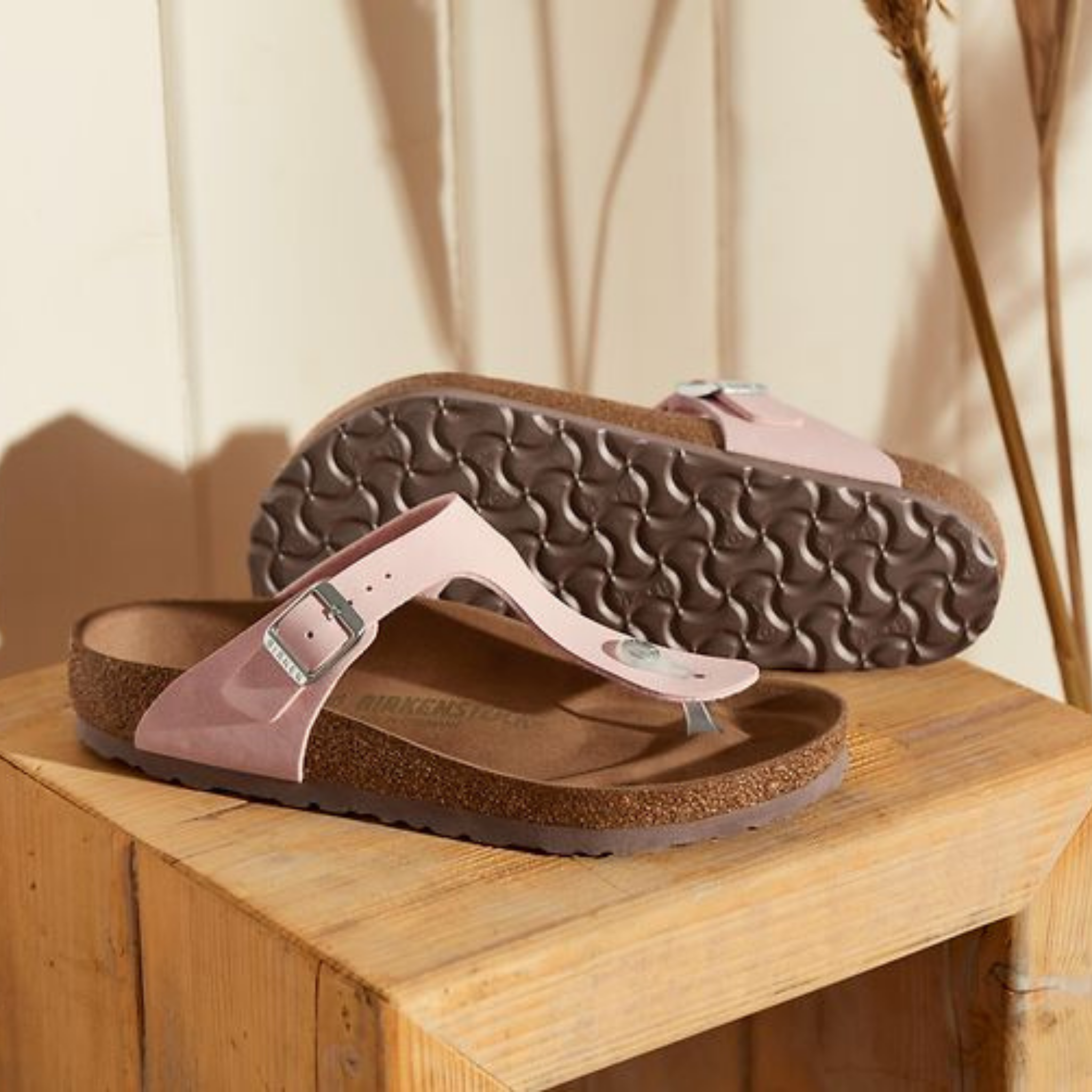 Pink Birkenstock sandals on a wood side table