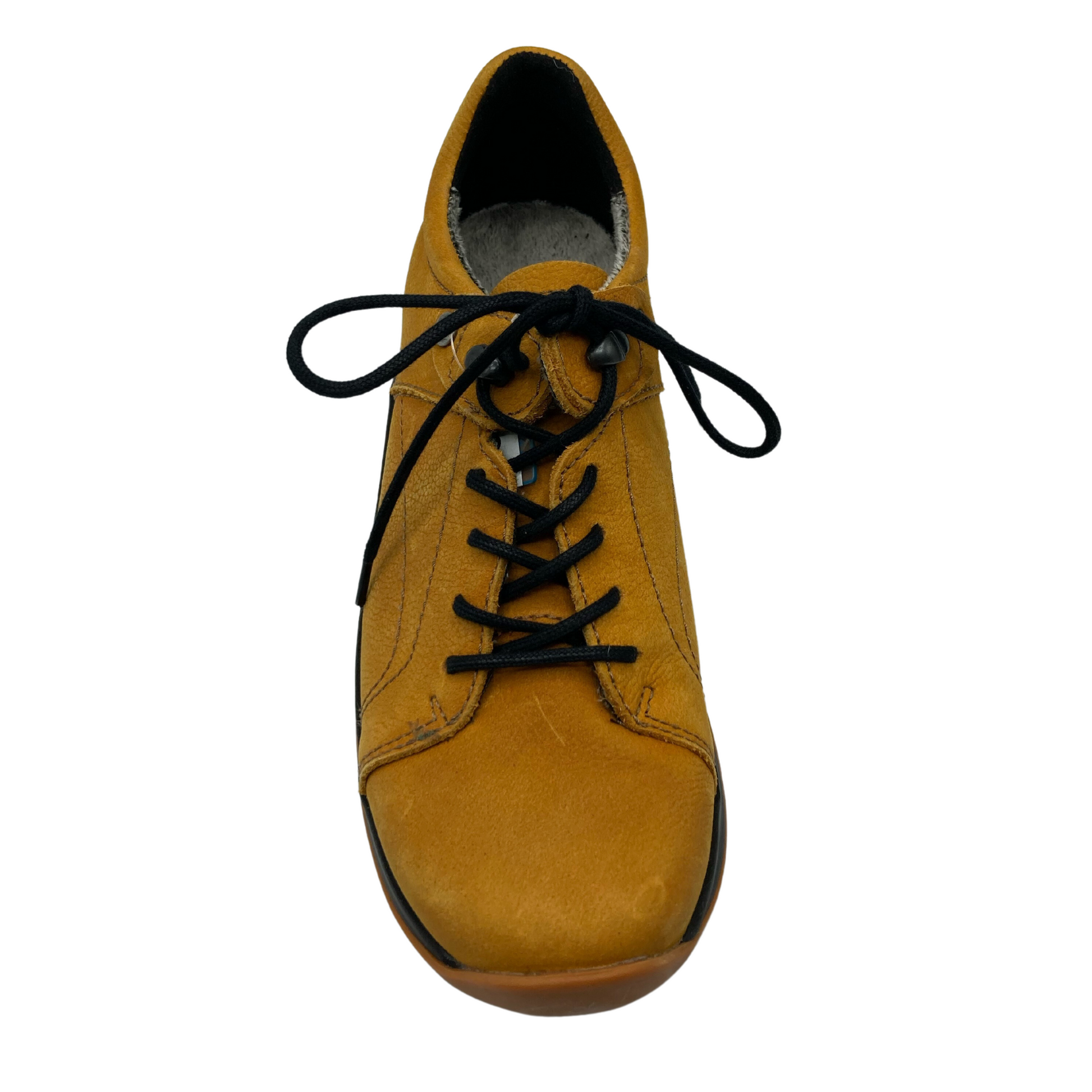 Top view of yellow nubuck sneaker with black laces and rounded toe