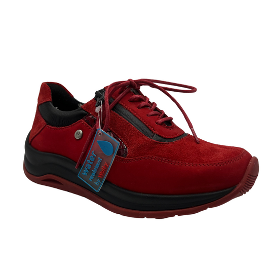 45 degree angled view of red leather sneakers with a water resistant upper, laces and side zipper closure.